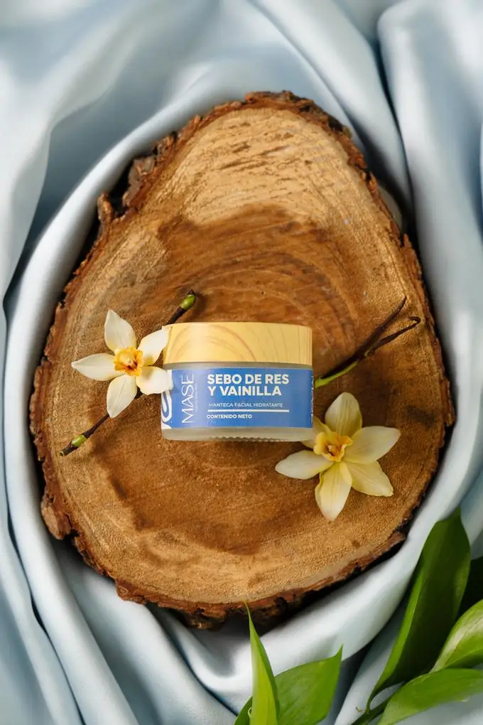 Manteca facial MASÉ Sebo de Res y Vainilla, frasco de 20g sobre madera con flores